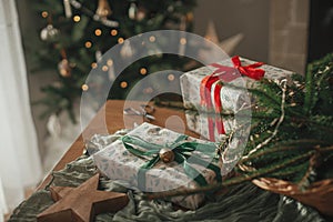 Merry Christmas and Happy holidays! Stylish wrapped christmas gifts, rustic basket with fir branches and modern decorations on