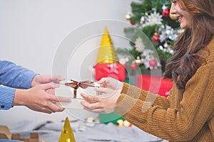 Merry Christmas and Happy Holidays! Young woman with a beautiful face in a yellow shirt shows joy with gift boxes in a house with