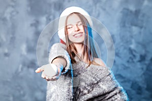 Merry Christmas and happy new year! Adorable happy girl with snowball hold in hand. Close portrait on gray background. Girl in sa