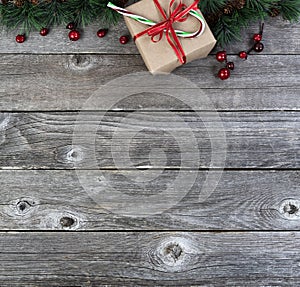 Merry Christmas or happy New Year background with fir tip branches and Gift box present with candy cane on rustic wood