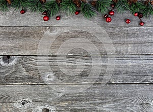 Merry Christmas or happy New Year background with fir tip tree branches and red berries on rustic wood