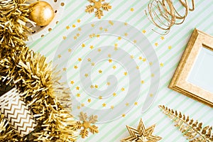 Merry christmas and happy new year background.top view of sparkling gold tinsel,ball,ornament decorate on green strip line table.