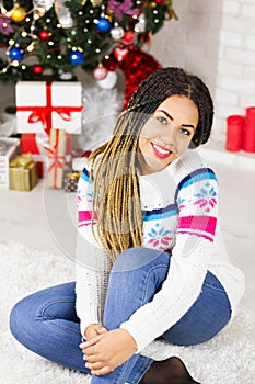 Merry Christmas, Happy New Year. Closeup african american young woman at home on Christmas Eve background, gift boxes, presents.