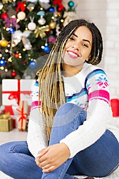 Merry Christmas, Happy New Year. Closeup african american young woman at home on Christmas Eve background, gift boxes, presents.