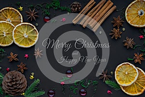 Merry Christmas and happy new year. composition on a black background of Christmas tree branches, cones, toys, cinnamon, dried