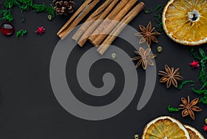 Merry Christmas and happy new year. composition on a black background of Christmas tree branches, cones, toys, cinnamon, dried