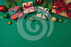 Merry Christmas and Happy New Year concept with gift box, ornaments and decorations on green background. Top view, flat lay