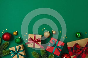 Merry Christmas and Happy New Year concept with gift box, ornaments and decorations on green background. Top view, flat lay