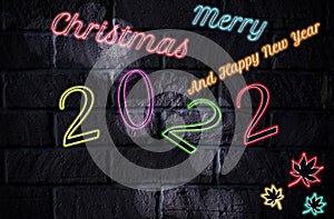 Merry Christmas and happy new year 2022 concept. glow text yellow, pink, red, green, orange, blue, purple and leaves maple chape photo