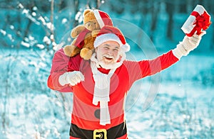 Merry Christmas and Happy New Year concept. Santa Claus pulling huge bag of gifts on white nature background.