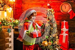 Merry christmas and happy new year. Cute little child boy play near christmas tree. Kid enjoy winter holiday at home