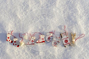 Merry Christmas and Happy New Year. Decorative items lying on fresh white sparkling snow on sunny winter day. Socks, mittens, hats