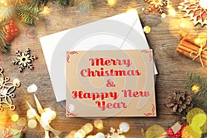 Merry Christmas and Happy New Year. Flat lay composition with greeting card on wooden table