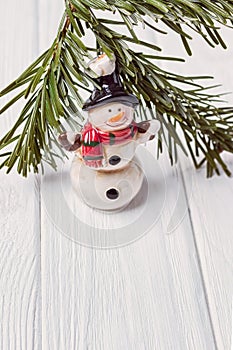 Merry Christmas and Happy New Year. Funny snowman and Christmas tree branch on white background. Free space