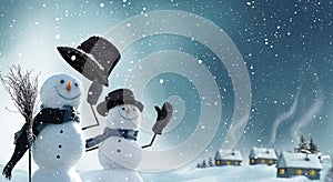 Two snowmen standing in winter Christmas landscape. photo