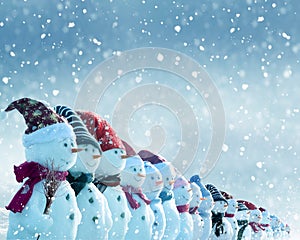 Christmas and New Year greeting card with copy-space.Many snowmen standing in winter Christmas landscape.Winter