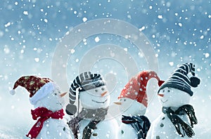 Merry Christmas and happy New Year greeting card with copy-space.Many snowmen standing in winter Christmas landscape.Winter