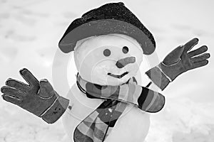 Merry Christmas and happy new year greeting card with copy-space. Snowman is standing in winter hat and scarf with red