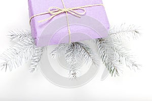 Merry Christmas and Happy New Year greeting card. Purple Gift box with twigs of fir on white background.