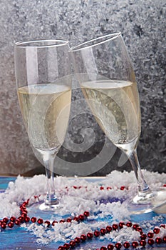 Merry Christmas, happy new year greeting card. Two nice tall wineglasses with white wine stay on frozen window background. Snow,