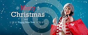 Merry Christmas and Happy New Year message with woman holding shopping bags