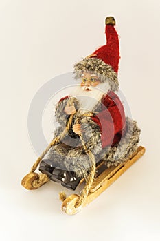 Merry Christmas and Happy New Year, model Santa Claus - Christmas decoration, toy on a wooden sled isolated on white background f