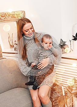 Merry Christmas and Happy New Year! Mom and son smiling in holiday living room, decorated for holiday. Portrait loving family