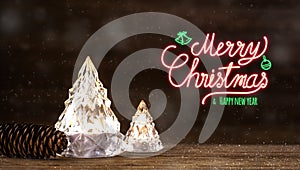 Merry Christmas and happy new year neon sign with modern glass Christmas tree with lights on dark wood table with wall for