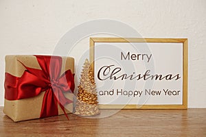 Merry Christmas and Happy New Year text with giftbox and Christmas tree decorate