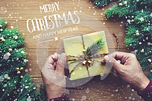 MERRY CHRISTMAS AND HAPPY NEW YEAR typography,text with human hand decorating gift box presents