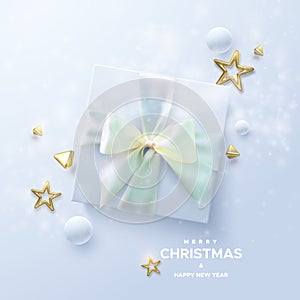 Merry Christmas and Happy New Year. White gift box with pastel mint green bow and crossing ribbons on white background