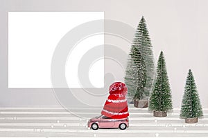 Merry Christmas happy New year, Winter illustration. Toy car in a winter hat rides past the Christmas trees. Minimal