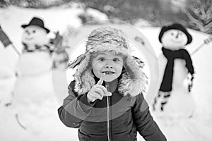 Merry Christmas and Happy new year. Winter portrait of little boy child in snow Garden make snowman. Cute kid - winter