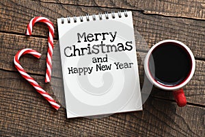 MERRY CHRISTMAS and HAPPY NEW YEAR words in a notebook on a wooden table. Time for Christmas