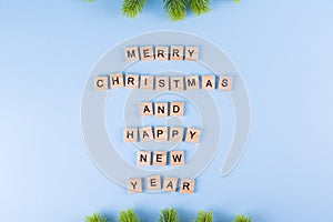 Merry Christmas and happy new year. Words from wooden letters on winter blue background. Template, greeting card.