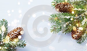 Merry Christmas holiday card or banner with snowy fir branches and conifer cones. Magic bokeh lights