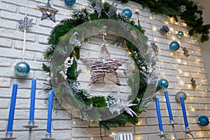 Merry Christmas interior decorative firtree wreath with toys, blue candles and garland lights