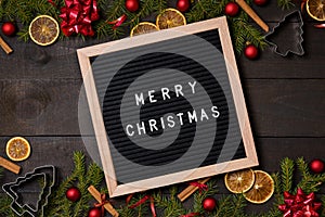 Merry Christmas letter board on dark rustic wood background wit