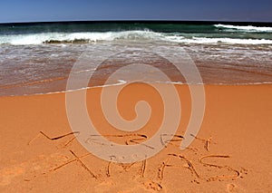 Merry Christmas lettering on the beach.