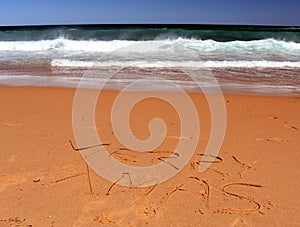 Merry Christmas lettering on the beach.