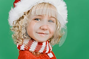 Merry Christmas Little girl in Santa hat on bright green vivid color background