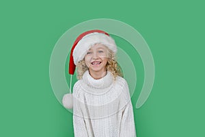 Merry Christmas Little girl in Santa hat on bright green vivid color background
