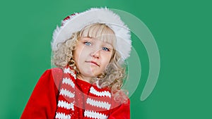 Merry Christmas Little girl in Santa hat on bright green vivid color background