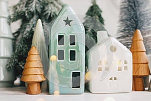Merry Christmas. Christmas little houses and trees with golden lights bokeh on white background. Festive modern decor. Happy