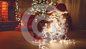 Merry Christmas! mother and child daughter with glowing garland