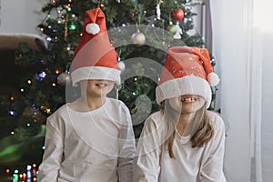 Merry Christmas and New Year. Cute brother with sister, boy and girl have fun under the Christmas tree. Children with Christmas