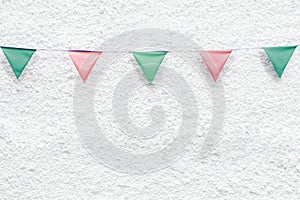 Merry Christmas Party flags bunting hanging on white wall background on x`mas eve holiday event. Minimal hipster style design.