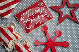 Merry Christmas red flatlay with wood and fabric snowflake decorations on a gray and white polka dot background