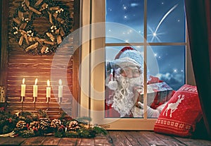 Santa Claus is knocking at window photo