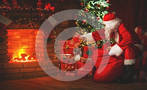 Merry Christmas! santa claus near the fireplace and tree with gi